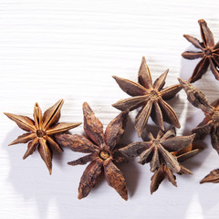 Star shaped anise seeds on a white wooden background