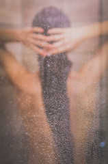 Young beautyful woman under shower in bathroom