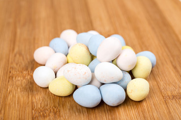Pastel chocolate eggs on a wood background