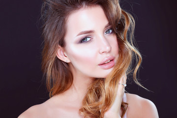 Fototapeta premium Portrait of beautiful young woman face. Isolated on dark background