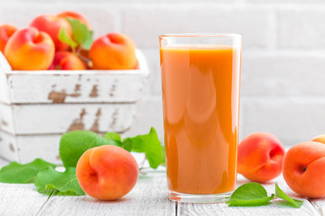 Apricot juice and fresh fruits with leaves
