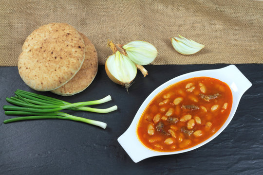 Traditional Turkish cuisine. Kuru Fasulye . Haricot Bean with onion, scallion and rustic bread