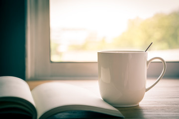 A cup of coffee is placed at the window.