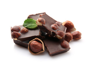 Broken chocolate pieces with nuts and mint leaves, isolated on white