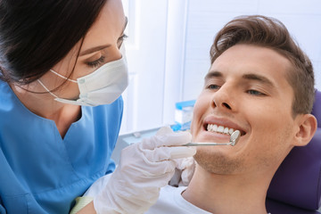 Naklejka premium Dentist examining patient teeth in clinic