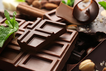 Heap of broken chocolate pieces with mint, close up