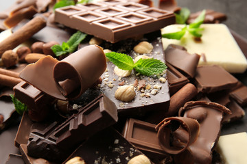 Heap of broken chocolate pieces with mint, close up