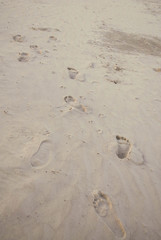 Footprints in beach sand at sunset blue cast.psd
