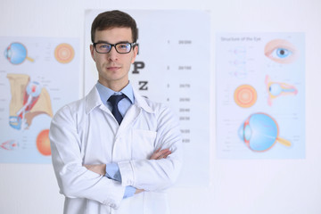Handsome young ophthalmologist in clinic - obrazy, fototapety, plakaty