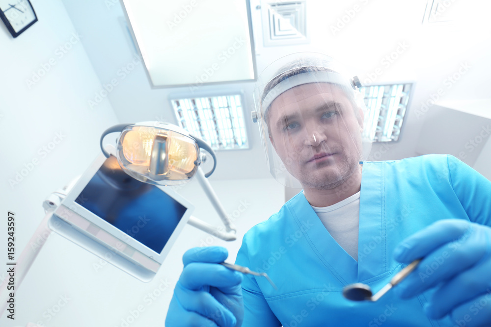 Wall mural Dentist with mirror and periodontal explorer in clinic