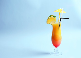 Glass of Tequila Sunrise cocktail on light background