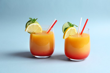 Glasses of Tequila Sunrise cocktail on light background