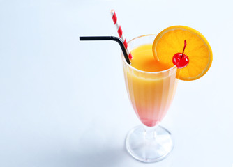 Glass of Tequila Sunrise cocktail on light background