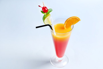 Glass of Tequila Sunrise cocktail on light background