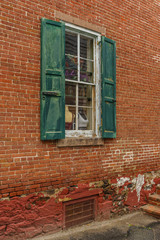 Fototapeta na wymiar Old house red wall with green wooden window