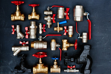 Top view of a set of plumbing ware consisting of faucets closeup on black background