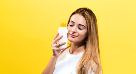 Young woman a bottle of sunblock