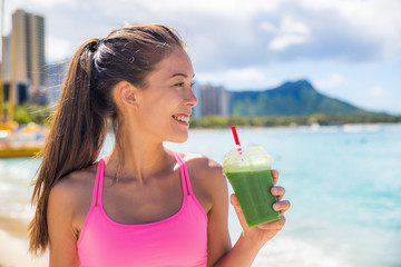 Sport fitness woman drinking healthy green detox juice, vegetable smoothie at running workout on...
