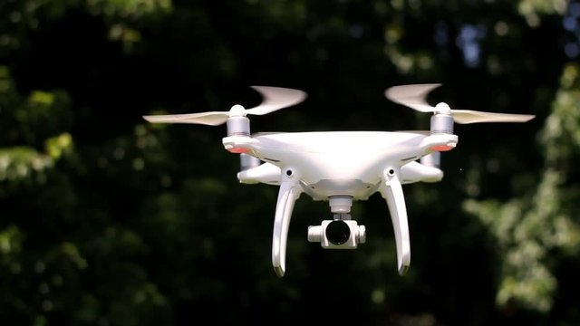Drone Camera turning to face the camera in a wooded area