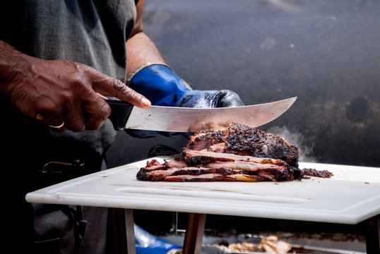  Cook slices beef fresh out of the smoker at a local food festival
