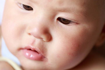 A baby's facial features; a curious expression
