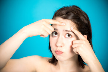 young woman squeezing a pimple, men's skincare concept