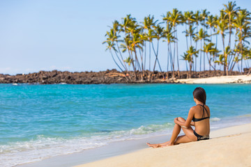 Hawaii beach travel tropical getaway bikini girl on Big island. Hawaiian tropical nature landscape with palm trees and volcanic beach in background.