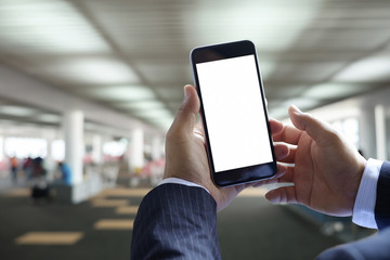 business man hands hold mobile blank screen of smart phone at airport lounge in airport terminal.