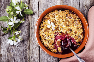 Cherry blackberry crumble with oatmeal crispy crust on vintage rustic wooden table. Healthy...