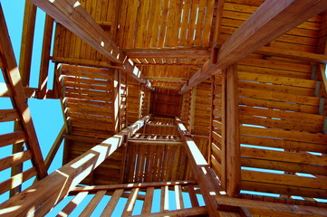 Kręte drewniane schody widziane od spodu - wejście na wieżę widokową w Mieroszowie - obrazy, fototapety, plakaty