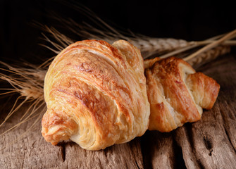 Tasty croissants on wooden background.