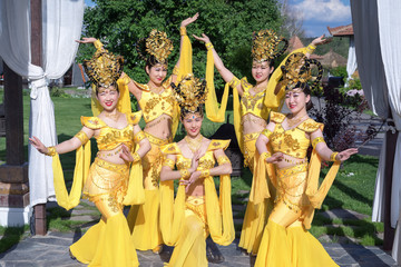 Naklejka premium group of five asian women actresses in traditional chinese yellow costumes outdoor