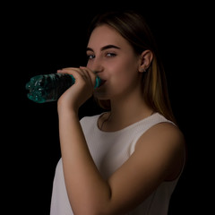 Young pretty woman drinks water Bottle or glass  of spring water  