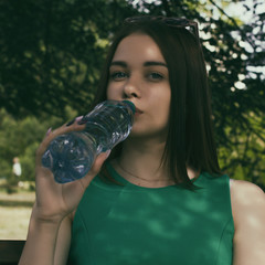 Young pretty girl drinks fresh water, outdoor  