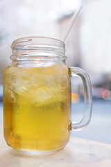 Iced tea in a mason jar with a straw. Selective focus with background blur