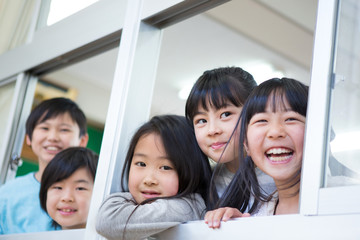 窓から顔を出す小学生