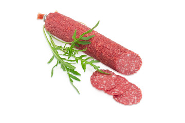 Salami and twig of the arugula on a light background