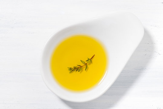 olive oil with thyme in a bowl, top view
