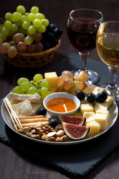 Plate with deli snacks and glasses of wine, vertical