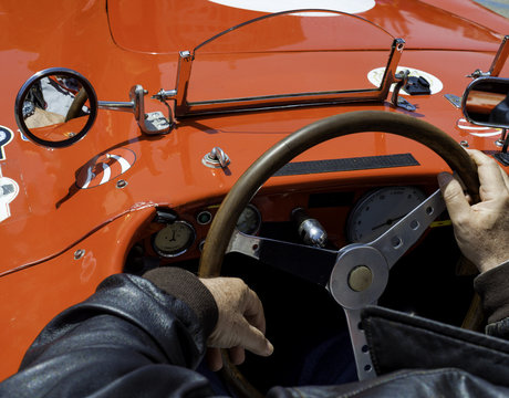 Close-up of the cockpit of vintage retro sports car..Visible the steering wheel, fuel level indicator, oil pressure and water