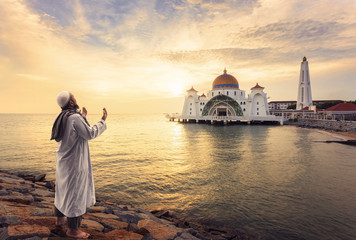 Muslim pray at the Malacca Straits Mosque ( Masjid Selat Melaka) near Malacca Town, Malaysia - obrazy, fototapety, plakaty