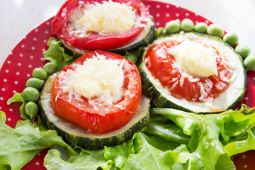 zucchini and tomatoes, baked with cheese on lettuce leaves. Selective focus.