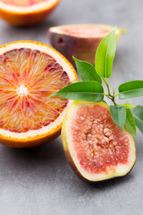 Mixed citrus fruit figs, limes on a gray background.