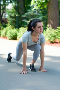 Exercise outdoors. Beautiful young girl is exercising in the park. Exercise stress.