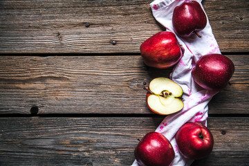 red apples and a kitchen towel on wooden background. fruit, natural food