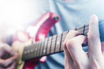 Close up of Male hands playing electric guitar, Flare from the sunlight, Selective focus