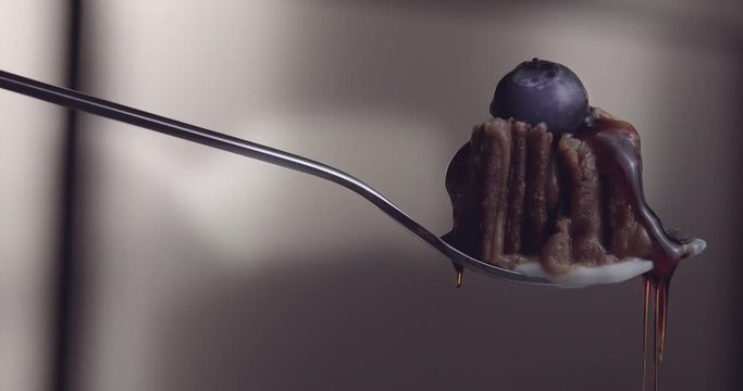 a piece of cake qith cream mapple suryp and blueberry on fork