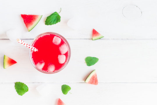 Watermelon juice and watermelon slices on wooden white background. Flat lay, top view
