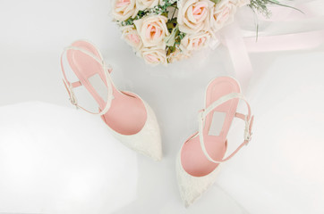 High Heel Laced Wedding Bridal Shoes With Pink Roses Flower Bouquet On White Background Shot From The Top