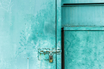 close up on green door with the key locked, abstract background with vintage filter. to show the old texture on metallic.